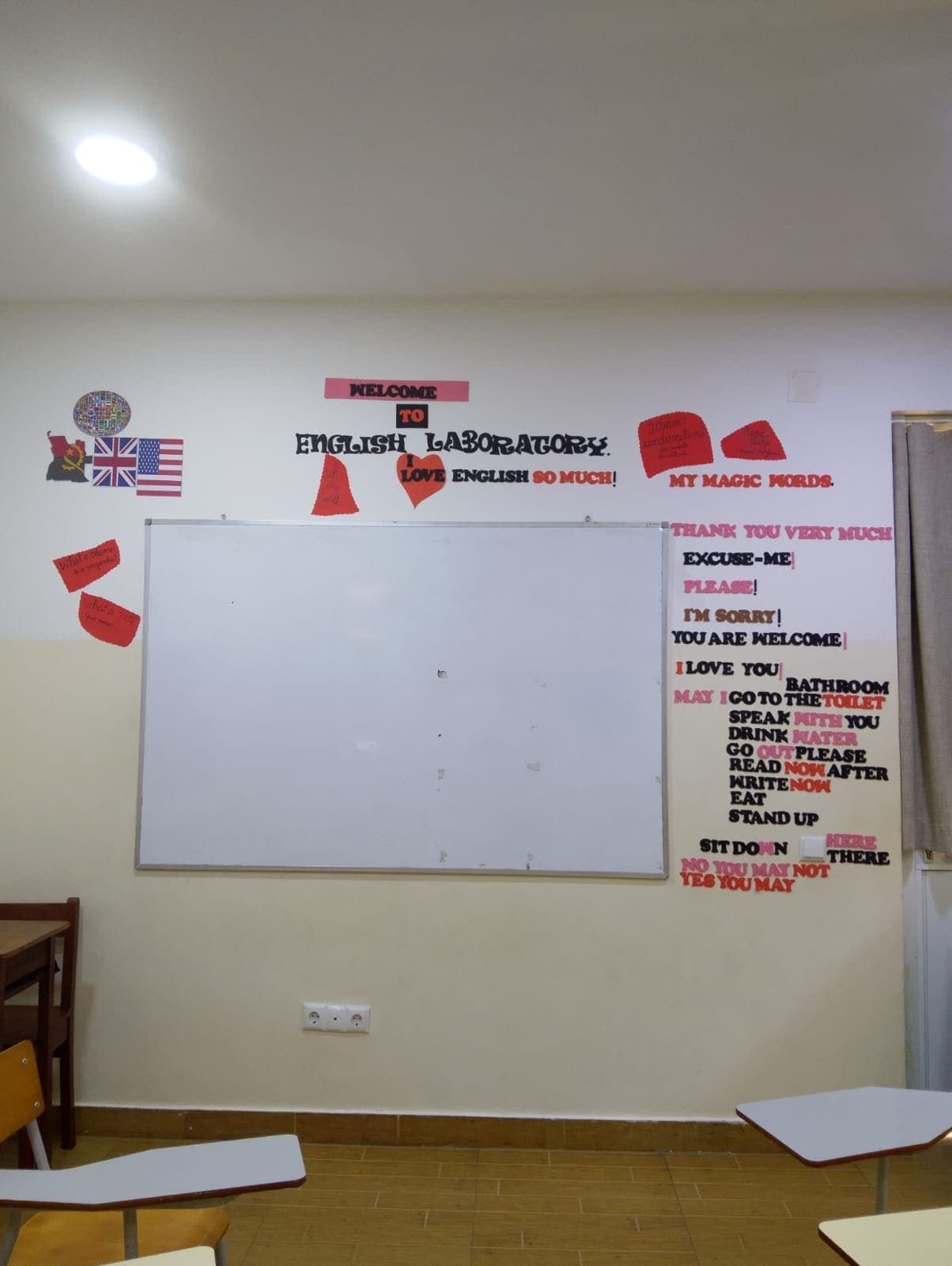 Sala de aula com quadro branco e expressões em inglês na parede