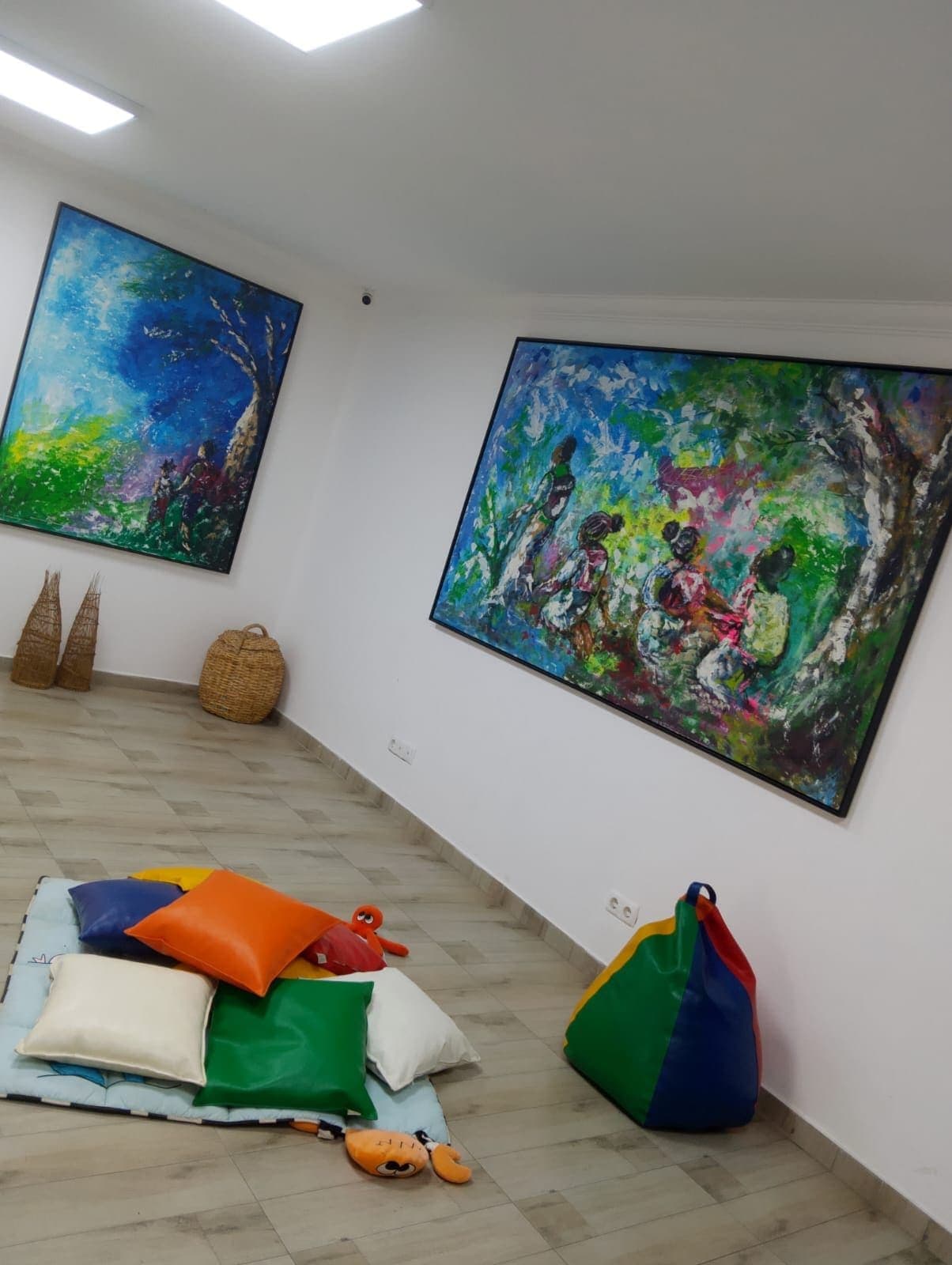 Sala com pufes, tapetes e quadros pintados na parede