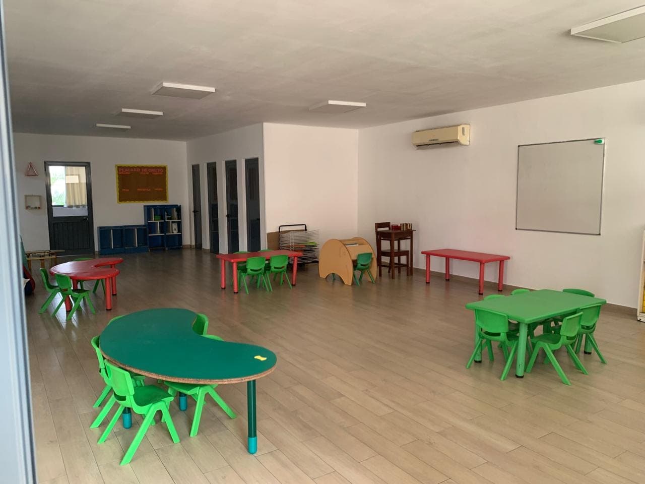 Sala do centro infantil, com mesas e cadeiras coloridas