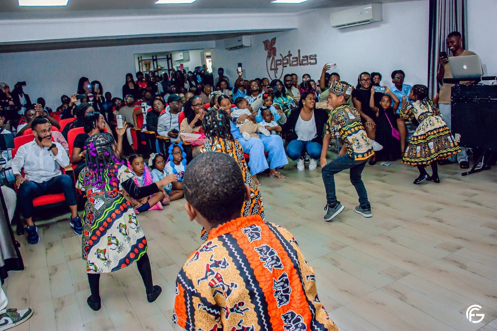 As famílias assistem às apresentações no auditório